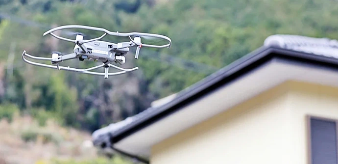 住宅の屋根を空から点検するドローン